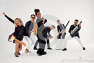Portrait of diverse group of young people musical band playing with instruments - isolated on white background. Stock Photo