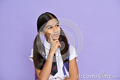 Portrait of dreamy latin schoolgirl isolated on violet background. Stock Photo