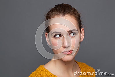 Dubious beautiful girl looking up, listening, observing emotions, studio shot Stock Photo