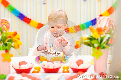 Portrait of eat smeared baby eating birthday cake Stock Photo