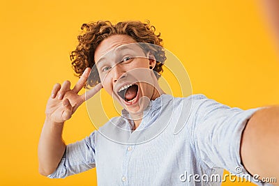 Portrait of ecstatic amazed man 20s taking selfie photo and show Stock Photo