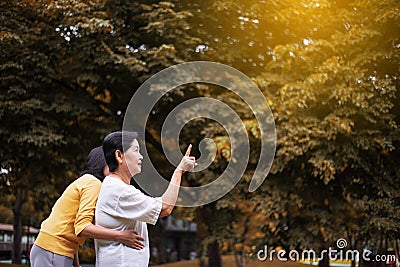 Portrait of a elderly asian woman with young female pointing something at outdoor together in the morning,Positive thinking Stock Photo