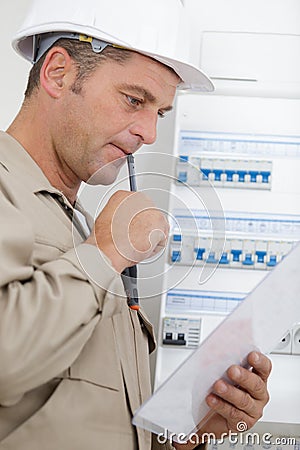 Portrait electrician standing next to fuseboard Stock Photo