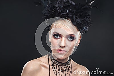 Portrait of an elegant Gothic blonde woman. Girl in wreath of black flowers and black cloak Stock Photo