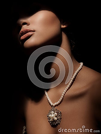 Portrait of an elegant and mystery smart lady with luxury jewelry made from precious metals on her neck Stock Photo