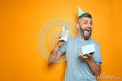 Portrait of emotional man with Birthday gift on color background Stock Photo