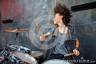 Portrait of emotional woman playing drums in studio Stock Photo