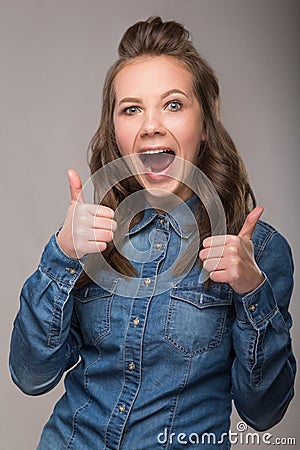 Portrait of energetic fun girl student on a gray background in a Stock Photo