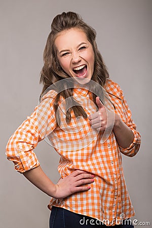 Portrait of energetic fun girl student on a gray background in a Stock Photo