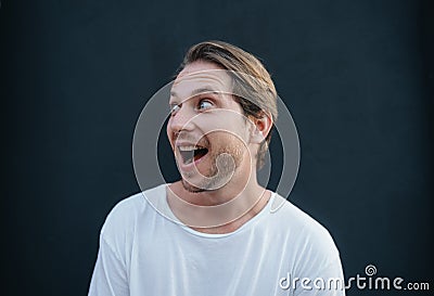 Portrait of european happy man in white t0shirt at dark wall Stock Photo