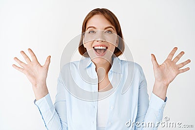 Portrait of excited and enthusiastic woman, spread hands sideways and scream of joy, winning, feeling happy and upbeat Stock Photo