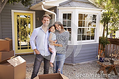 Portrait Of Excited Family Standing Outside New Home Stock Photo