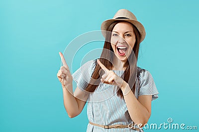 Portrait of excited young elegant woman wearing dress, straw summer hat pointing index fingers on copy space isolated on Stock Photo