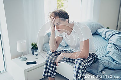 Portrait of exhausted unhappy man after hangover party have terrible fatigue migraine catch cold suffer sit on bed wear Stock Photo