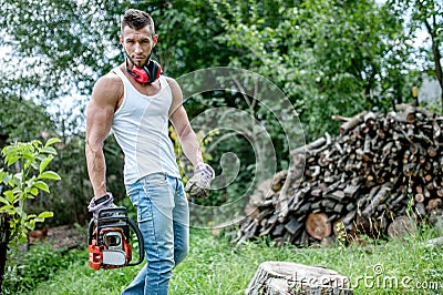 Portrait of expressive muscular lumberjack, man with chainsaw Stock Photo