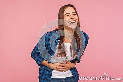 Portrait of extremely happy girl in checkered shirt holding her stomach and laughing out loud, chuckling giggling Stock Photo