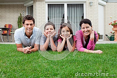 Portrait of family of four lying in backyard Stock Photo