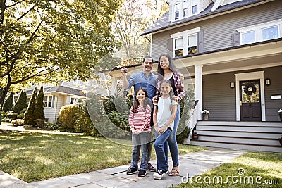 Portrait Of Family Holding Keys To New Home On Moving In Day Stock Photo