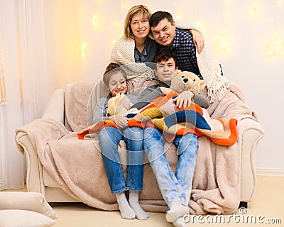 Portrait of a family sitting on a sofa at home, four people having fun together Stock Photo