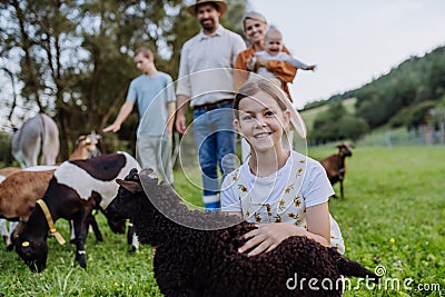 Portrait of farmer family petting donkey and goats on their farm. A gray mule and goats as a farm animals at the family Stock Photo