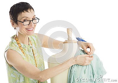 Portrait Of Fashion Designer Pinning Clothes To Mannequin Stock Photo