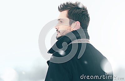 Portrait of fashion handsome man in winter snowstorm looks, profile view Stock Photo