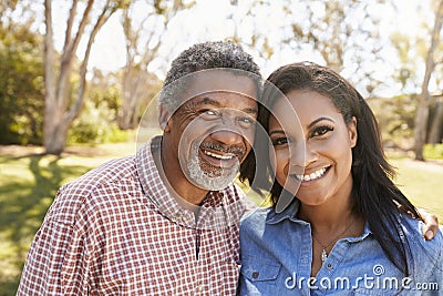 Portrait Of Father And Adult Daughter In Park Together Stock Photo