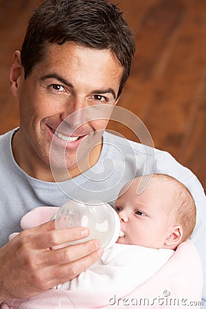 Portrait Of Father Feeding Newborn Baby At Home Stock Photo