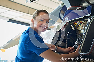 Portrait Of Female Aero Engineer Working On Helicopter In Hangar Stock Photo