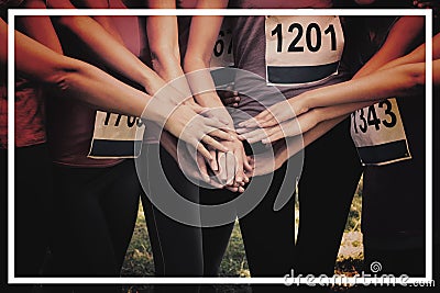 Female breast cancer marathon runners stacking hands Stock Photo