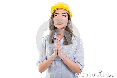 Portrait of female constructor making praying gesture Stock Photo