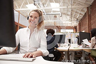 Portrait Of Female Customer Services Agent Working At Desk In Call Center Stock Photo