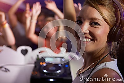 Portrait Of female DJ With Crowd In Background Stock Photo