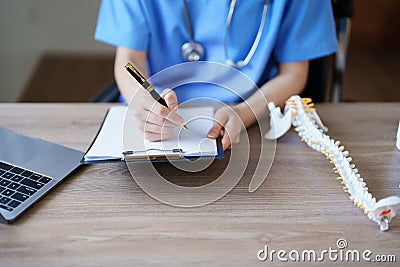 Portrait of a female doctor Center of Excellence from Orthopedic Center are using computers and documents to analyze Stock Photo