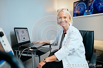 Portrait Female Doctor Working In Hospital Office With Computer Smiling Stock Photo