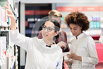 Portrait of a female experienced pharmacist reading indications Stock Photo