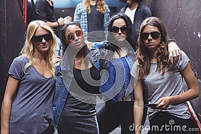 Portrait of female friends wearing sunglasses while staning together Stock Photo