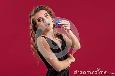 Portrait of the female gambler at the casino keeping poker chips in the hand Stock Photo