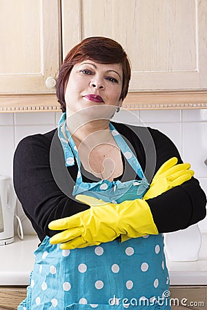 Portrait of female houseworker dusting kitchen Stock Photo