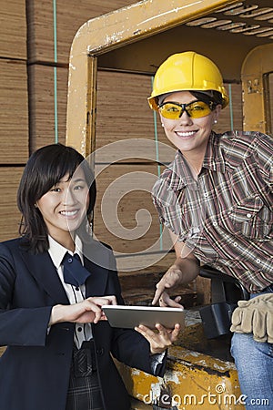 Portrait of female inspector and industrial worker using tablet PC Stock Photo