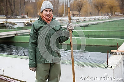 Portrait of female with landing net on fish farm Stock Photo