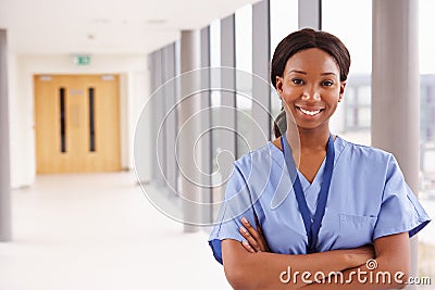 Portrait Of Female Nurse Standing In Hospital Corridor Stock Photo