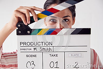 Portrait Of Female Videographer Holding Clapper Board On Video Film Production In White Studio Stock Photo