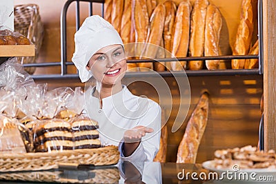 Portrait of friendly young woman at bakery display Stock Photo