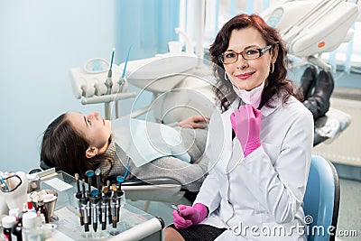 Portrait of friendly female dentist with patient in the chair at the dental office Stock Photo