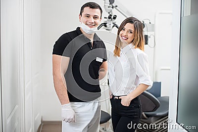Portrait of friendly male dentist with happy female patient in modern dental clinic. Dentistry Stock Photo