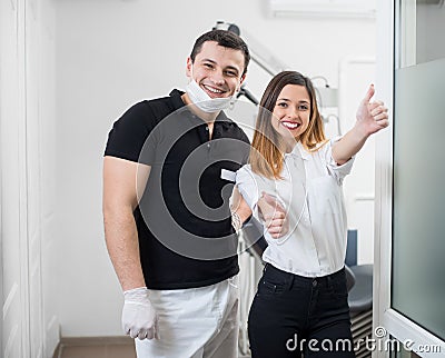 Portrait of friendly male dentist with happy female patient after treatment in modern dental office. Dentistry Stock Photo