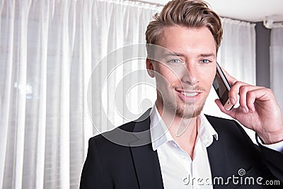 Portrait friendly young business man in suit on the phone Stock Photo