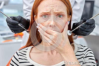 Portrait Of Frightened Redhead Female Patient Having Terrible Toothache, Pain Stock Photo
