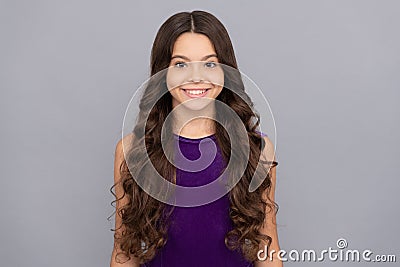 portrait of frizz child in purple dress. kid with curly hair. teen beauty hairstyle. Stock Photo